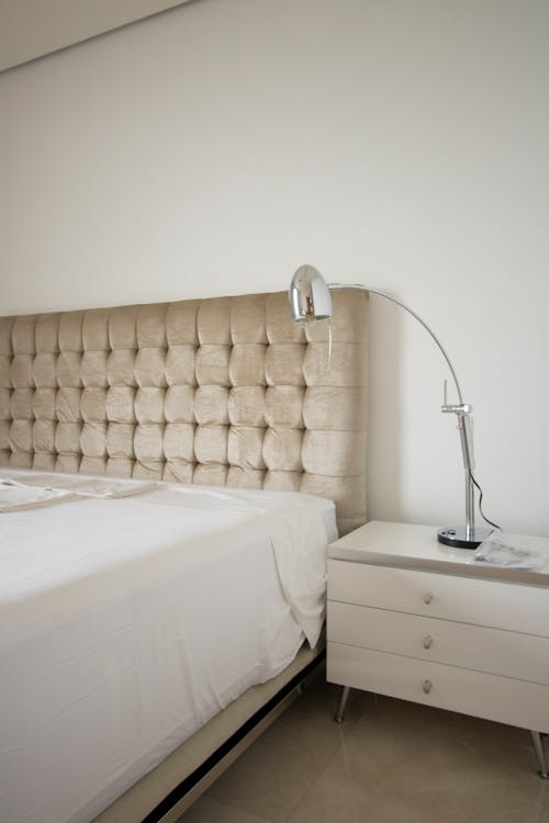 Free Silver Bedside Lamp on the White Nightstand Next to the Bed Stock Photo