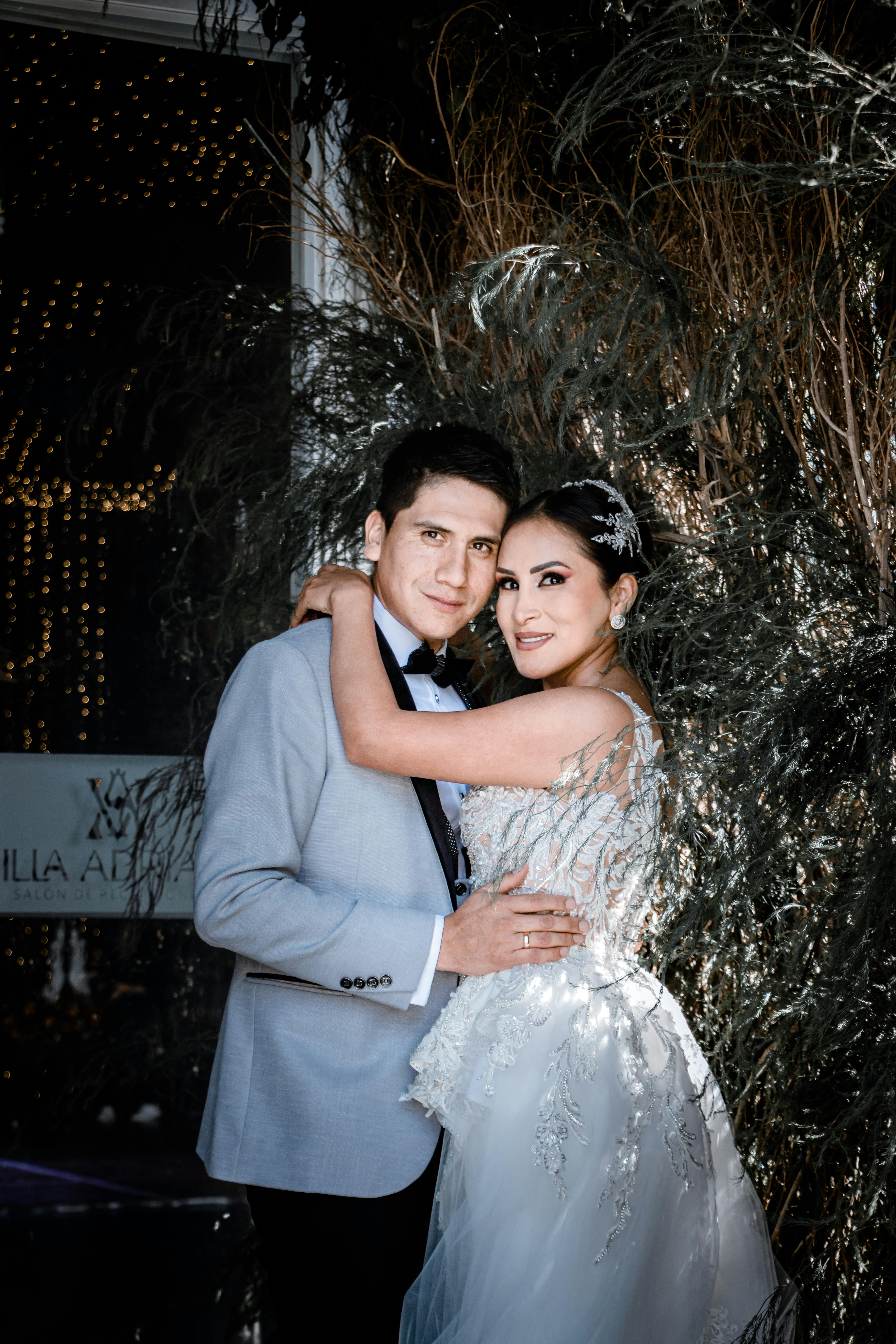 A loving bride and groom embrace in a serene outdoor wedding scene, exuding joy and intimacy.