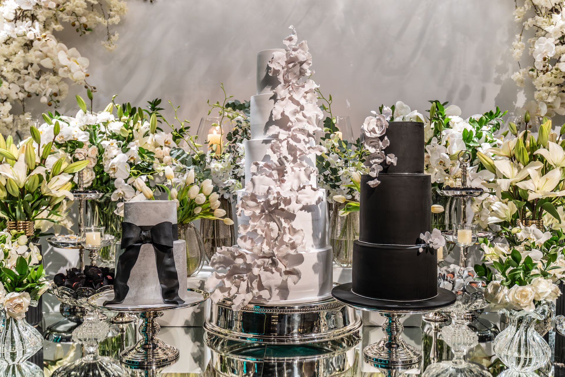 Luxurious multi-tier wedding cake surrounded by elegant floral arrangements