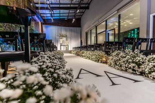 Free Beautifully decorated indoor wedding venue with white florals and elegant seating arrangement. Stock Photo