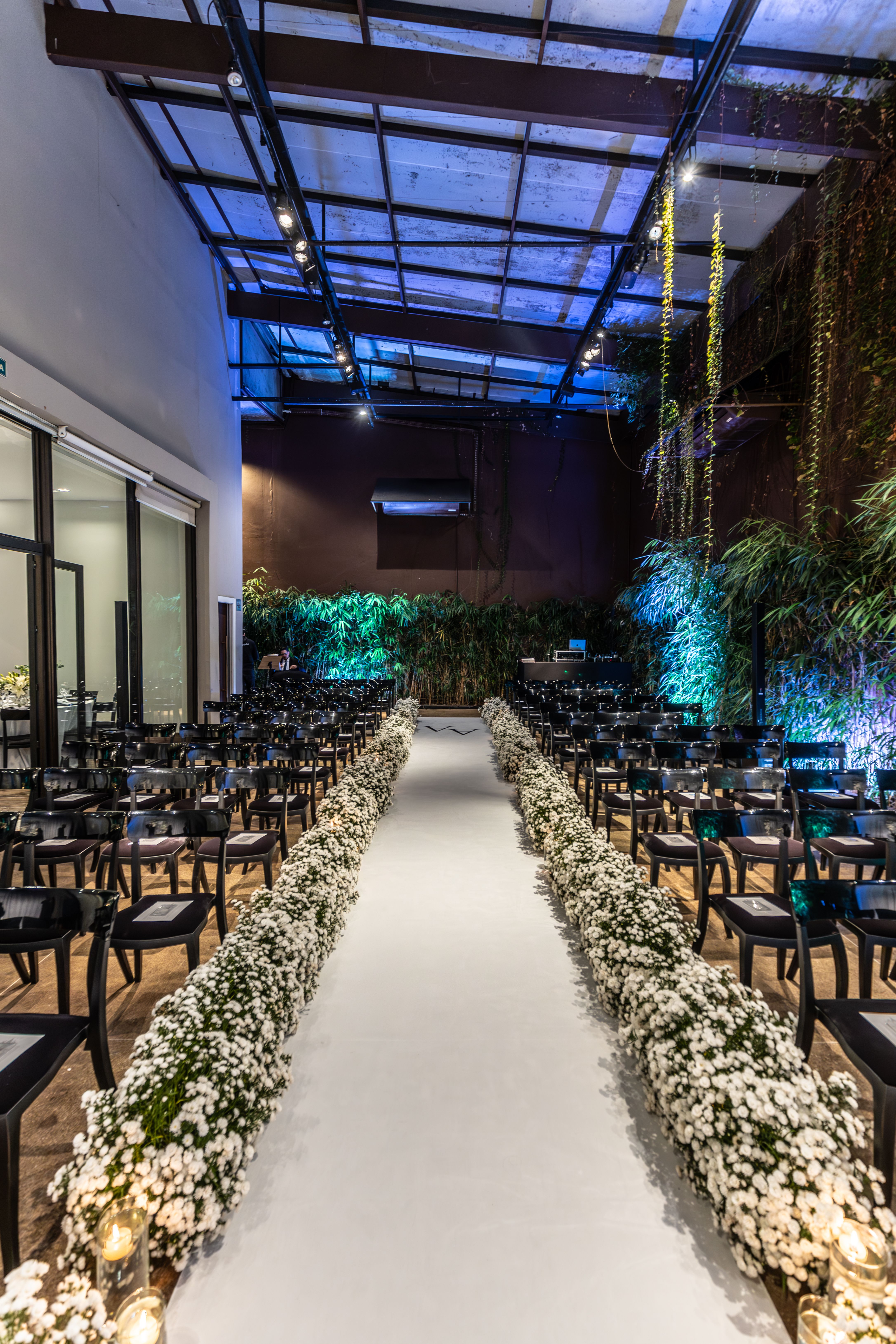 Beautifully decorated indoor wedding ceremony venue with a floral aisle and elegant chairs.