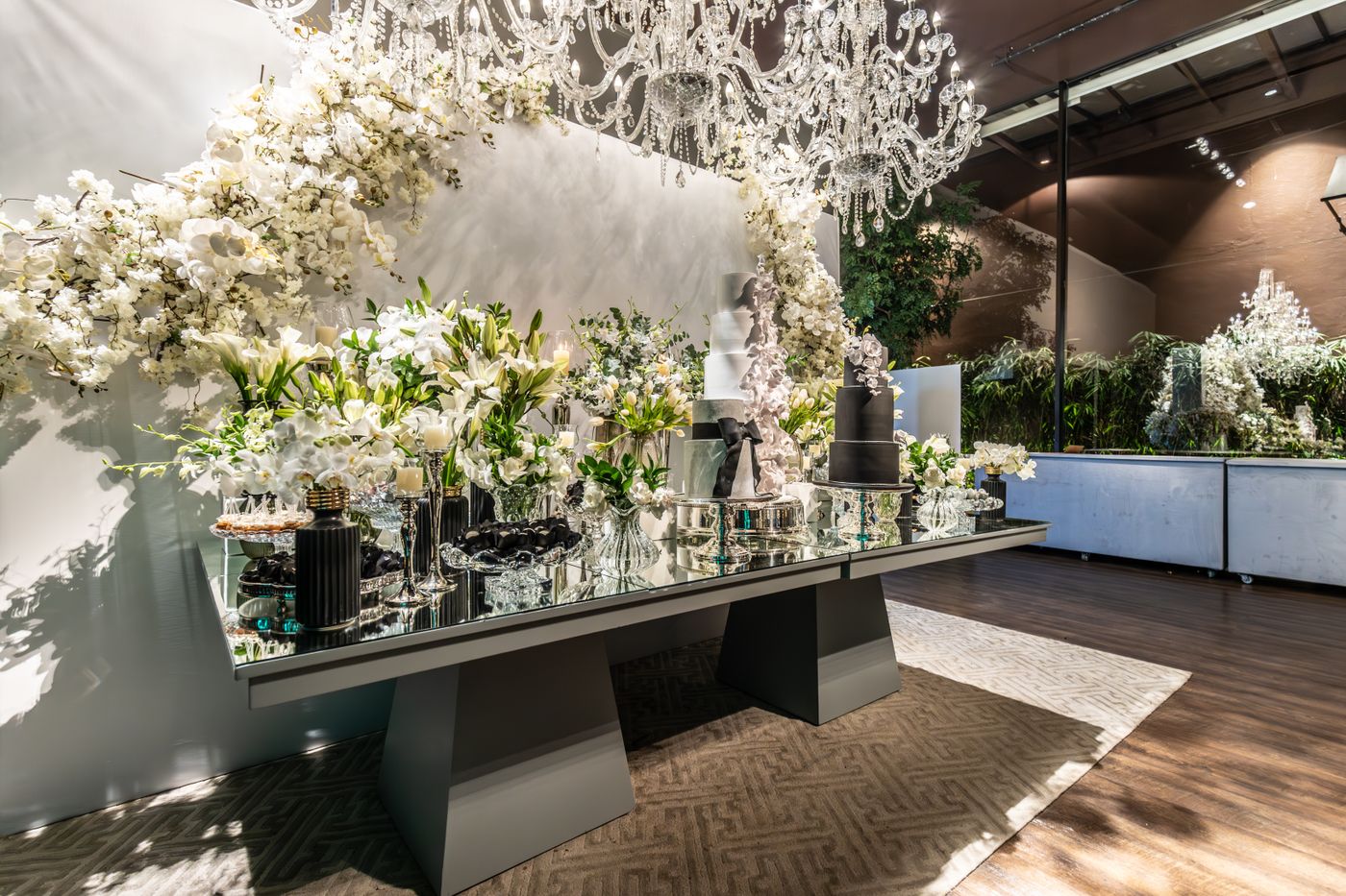 Large white floral wedding installation beneath chandeliers