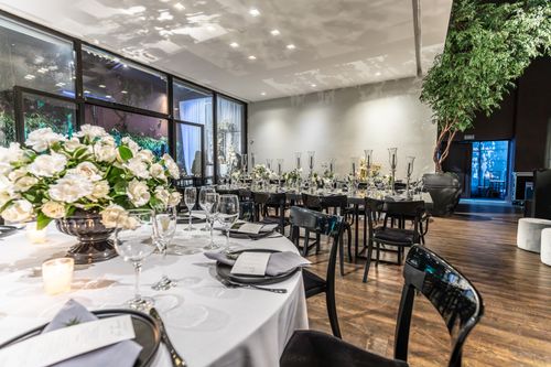 Free Elegant wedding setup with floral centerpieces in a modern banquet hall setting. Stock Photo