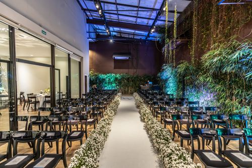 Free Beautiful indoor wedding venue adorned with lush greenery and elegant floral arrangements. Stock Photo
