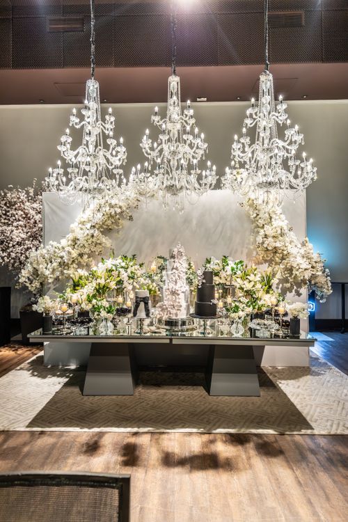 Free Luxurious wedding reception table adorned with flowers, chandeliers, and cakes. Stock Photo