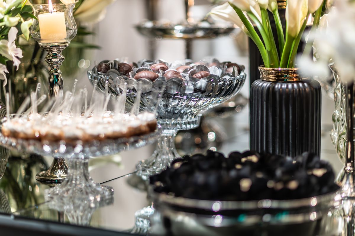 Luxurious table setting with desserts, candies and floral arrangements, exuding elegance.