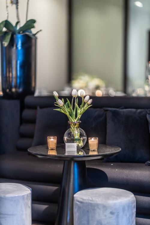 Free Stylish indoor table arrangement featuring white tulips and candles for a sophisticated ambiance. Stock Photo