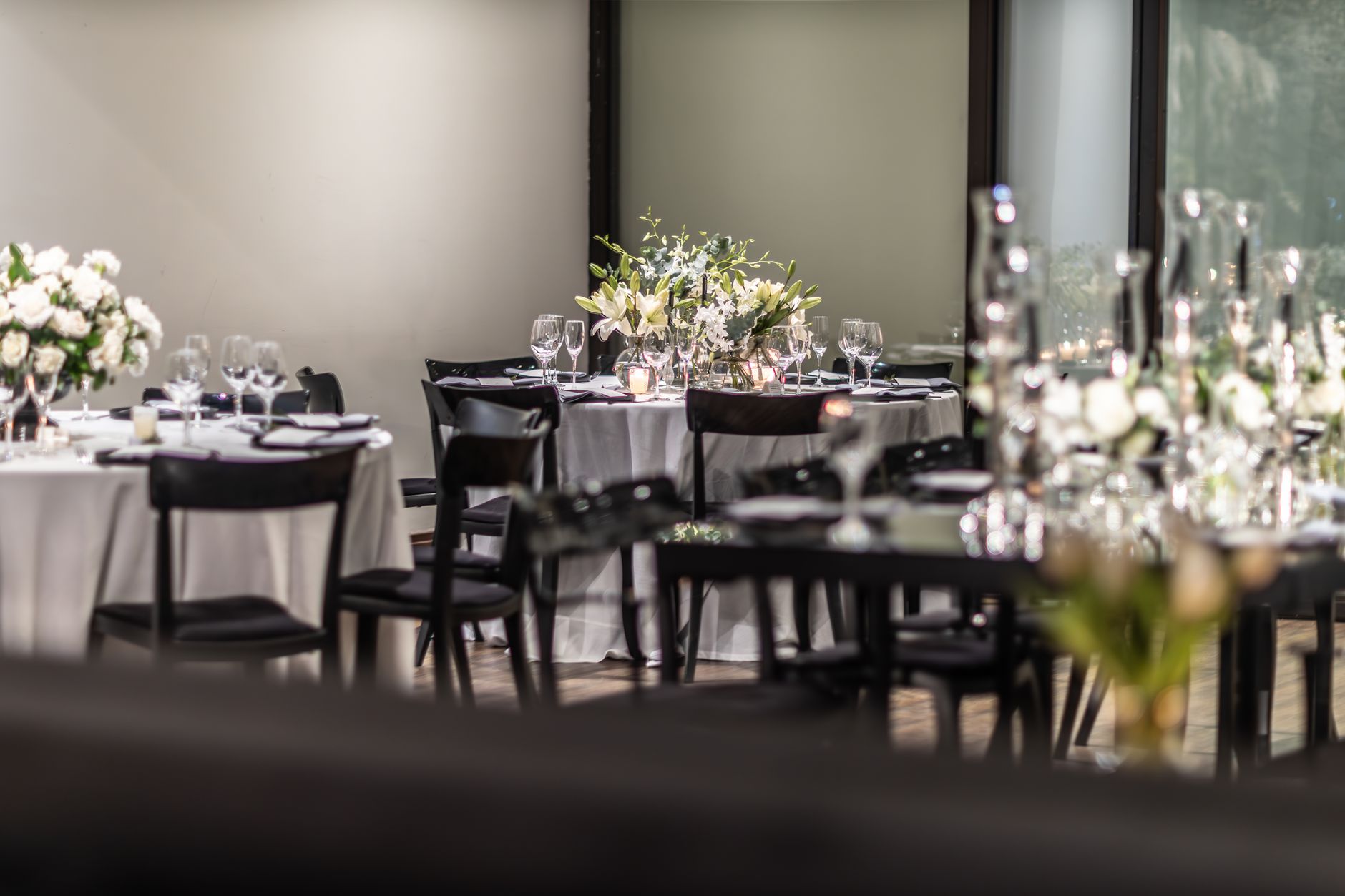 A minimalist luxury private dining room featuring a perfectly set table and sophisticated atmospheric lighting.
