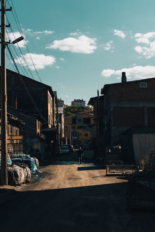 Free A lone man walks down a sunny alley in Gerede, Türkiye, showcasing urban architecture. Stock Photo