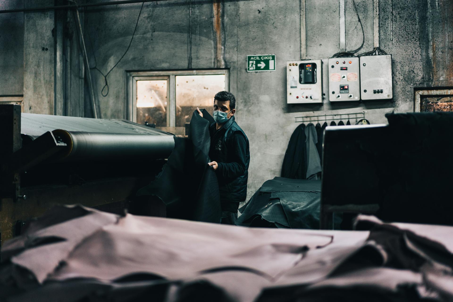 Worker Removing Sheets of Leather from a Conveyor Belt