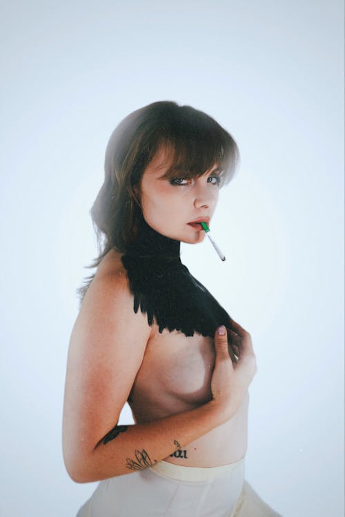 Shirtless Woman Covering Breast and Smoking Cigarette