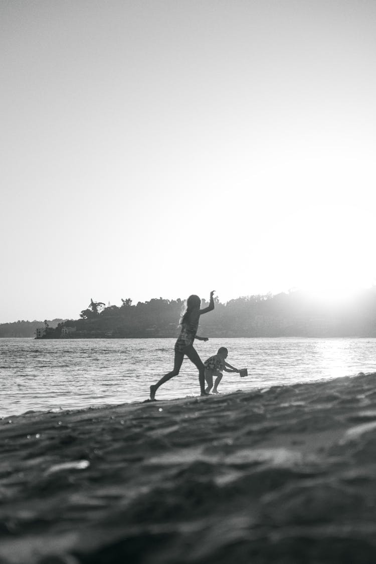 Children Playing On Beach At Sunset