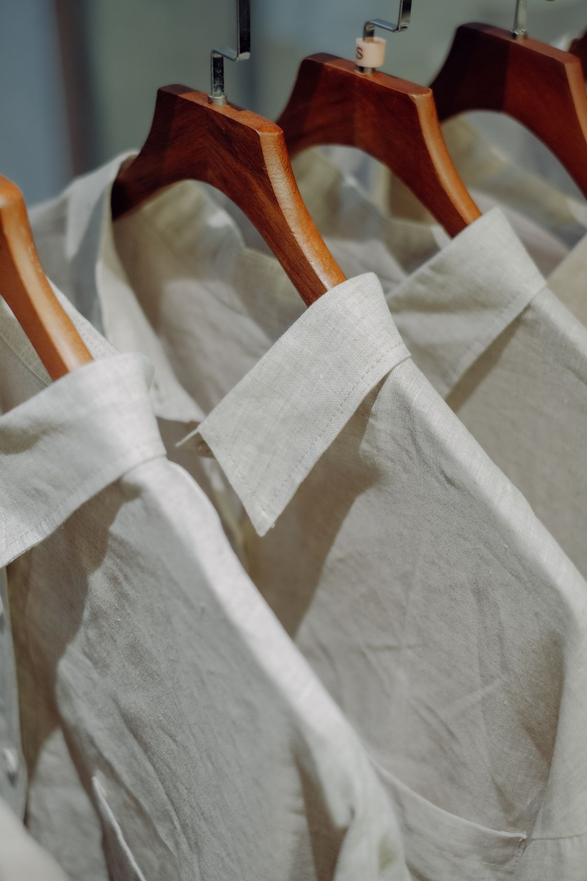 White shirts on wooden hangers, collars in close view
