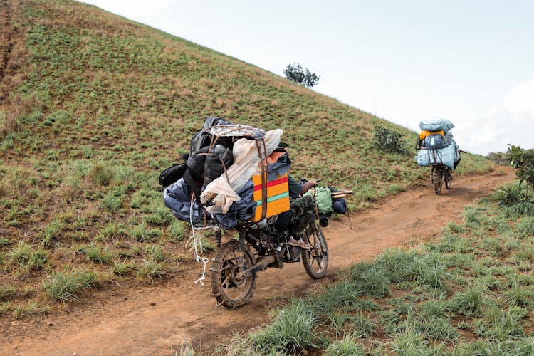 People Riding Motorbikes With Bags On Hill