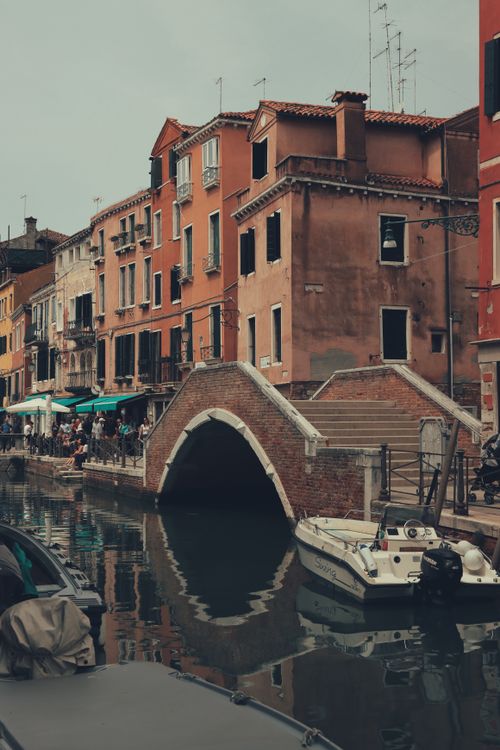 Free Charming view of a Venetian canal with historic buildings and a quaint bridge in Venice, Italy. Stock Photo