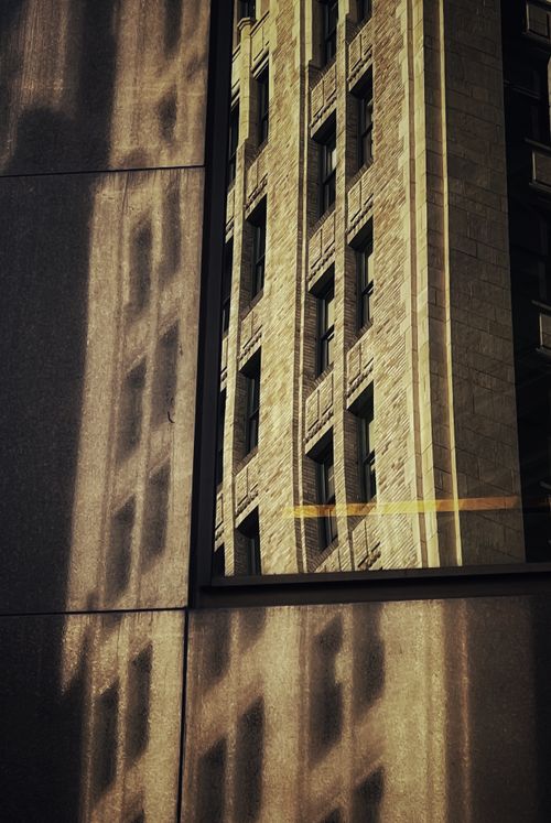 Free A classic building's reflection on a modern glass facade in an urban setting. Stock Photo