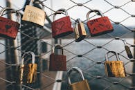 Red and Brown Padlock on Chain Link Fence