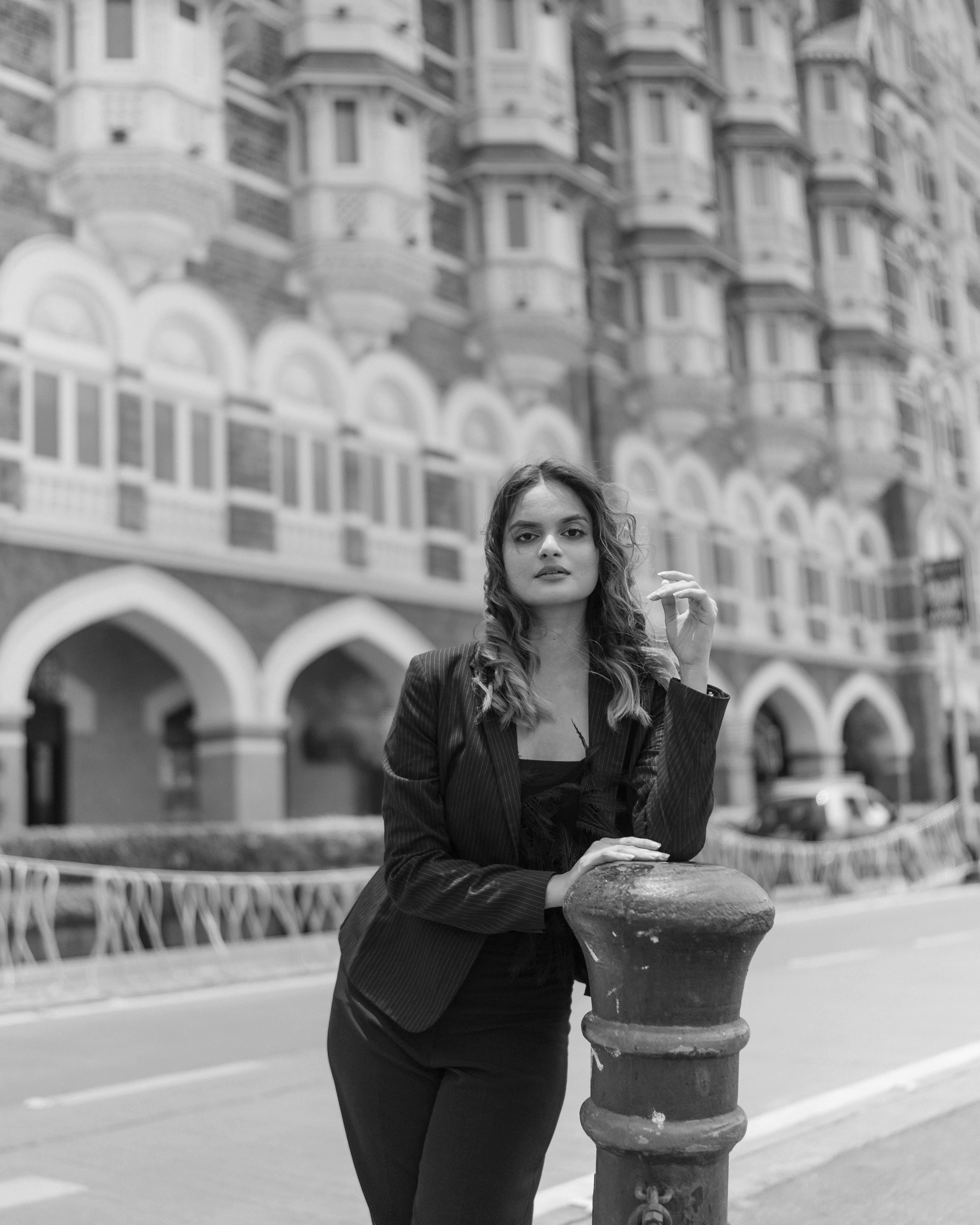 Elegant woman poses in stylish urban environment. Chic city style captured in monochrome.