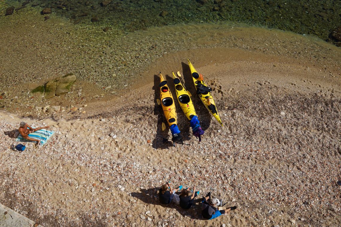 Yellow kayaks resting on a clear-water beach