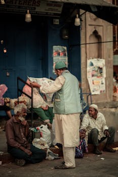 Men gathered on a Hyderabad street, reading a newspaper, in a candid moment.