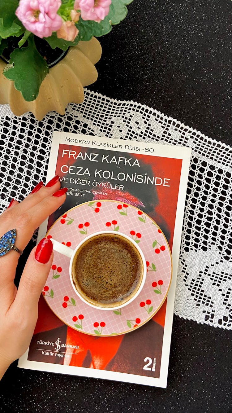 Woman Hand And Coffee Over Franz Kafka Book In Turkish