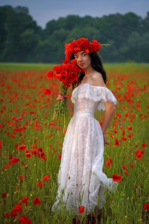 Woman in White Dress Posing with Poppy Flowers
