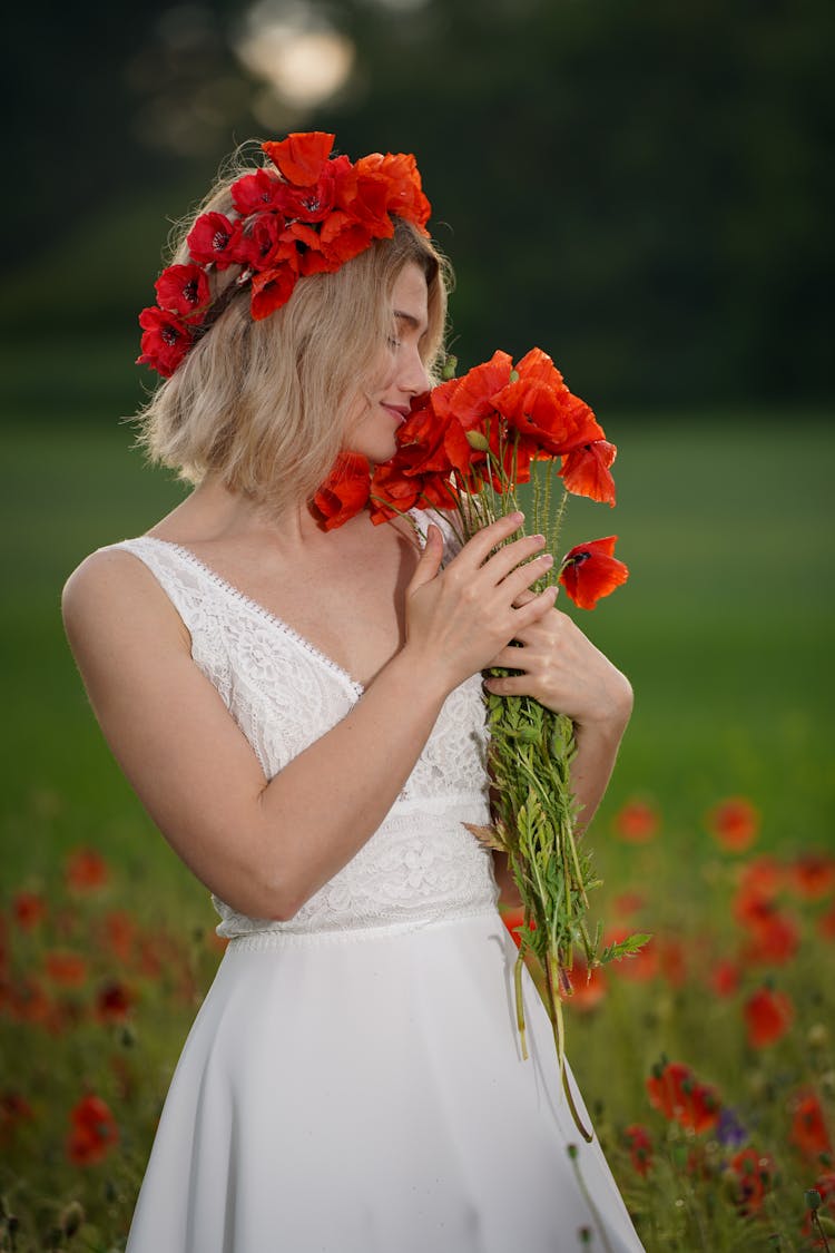 Woman Holding Bouquet Of Red Flowers On A Field 