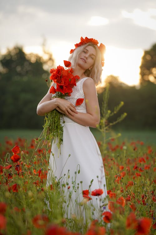 Blonde Woman in White Dress Posing with Poppy Flowers