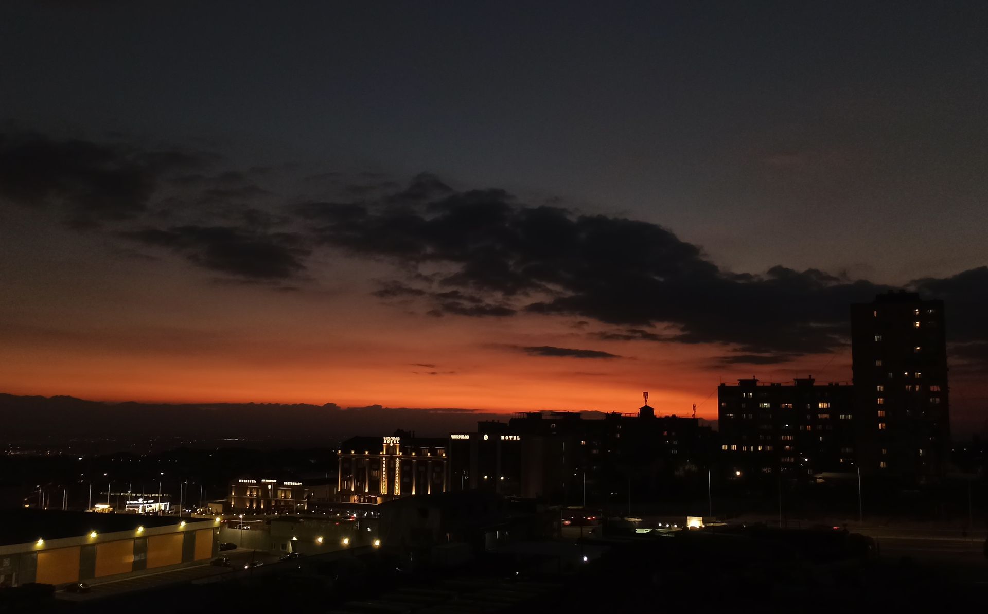 Stunning view of Yerevan cityscape at sunset with vibrant sky and city lights.