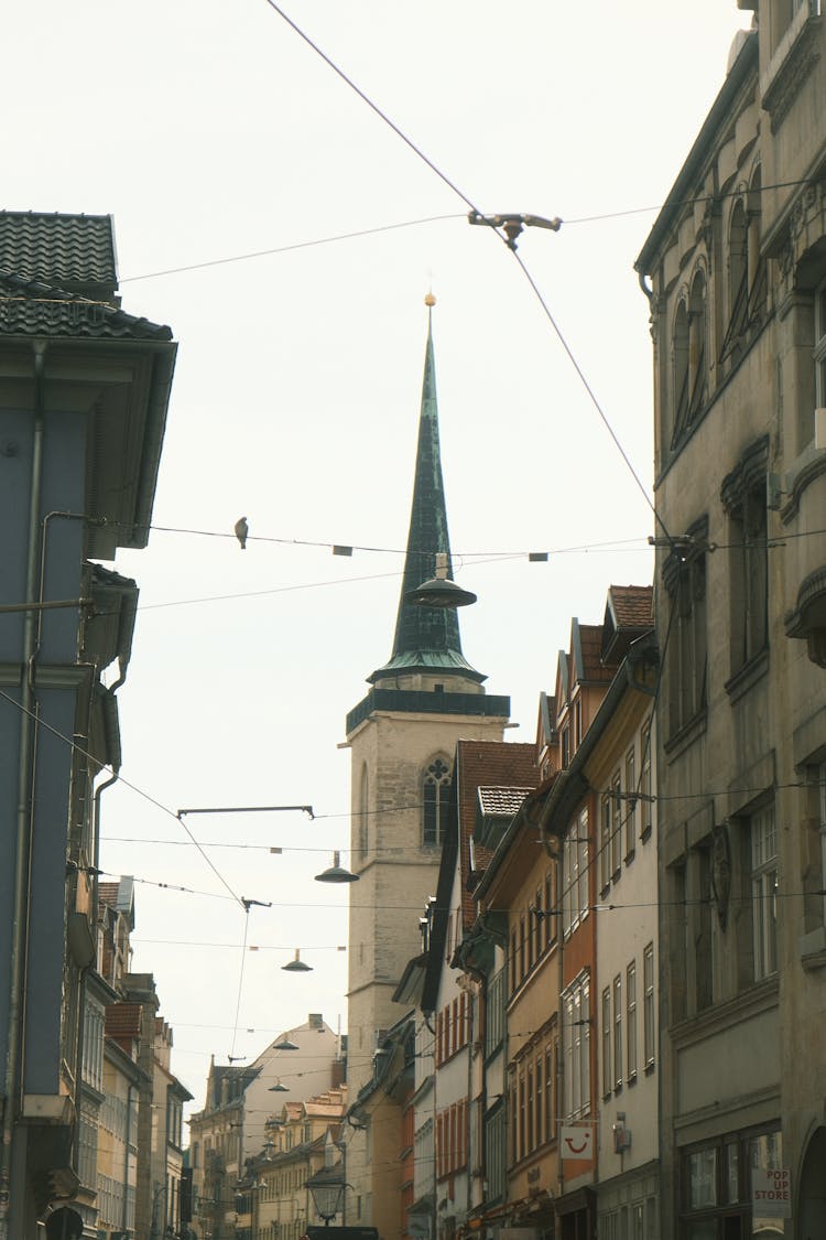 Church Tower Behind Buildings In Old Town