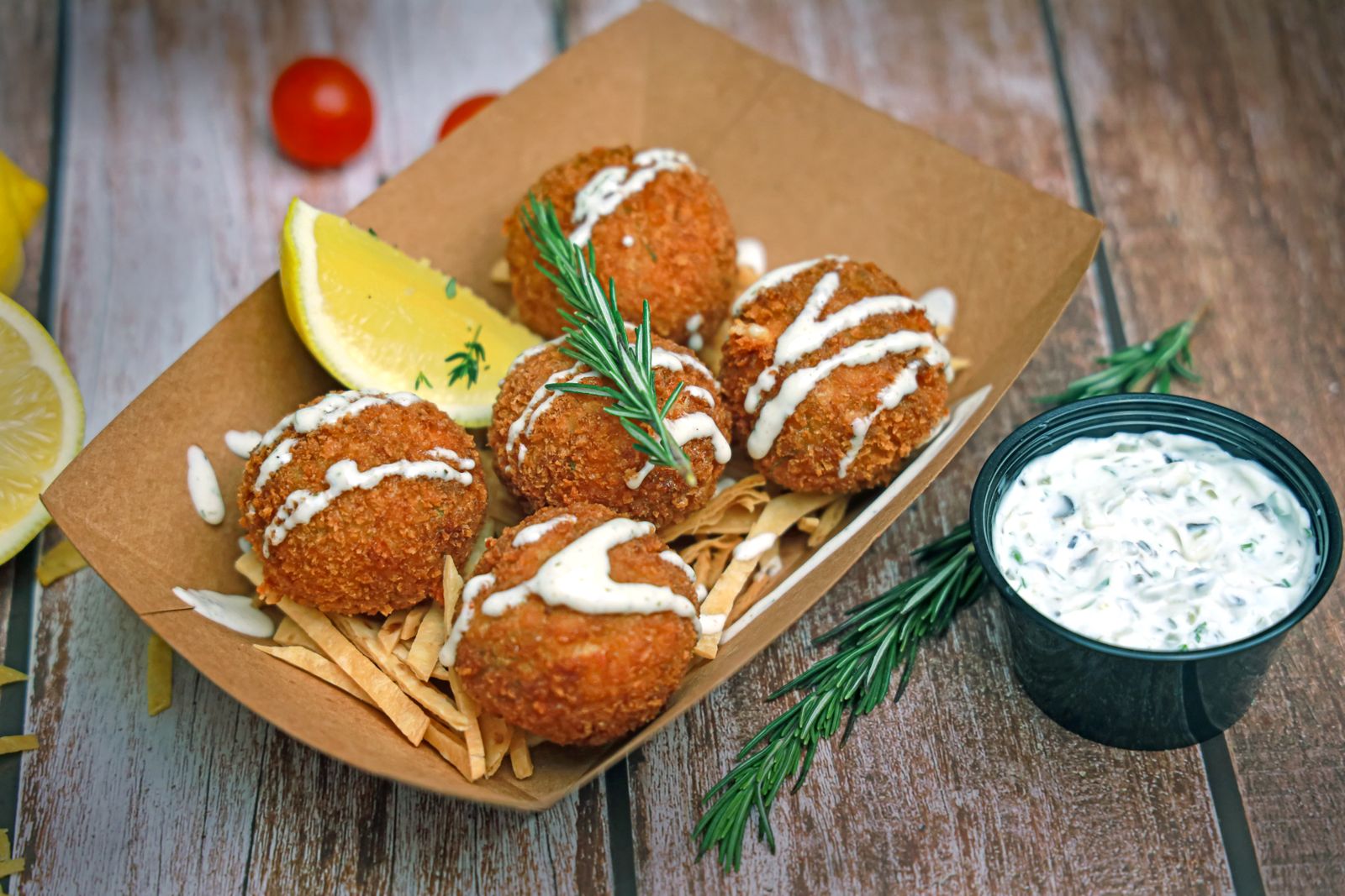 Crab cakes in a kraft tray with lemon and herb tartar sauce — photo by Shameel mukkath on Pexels