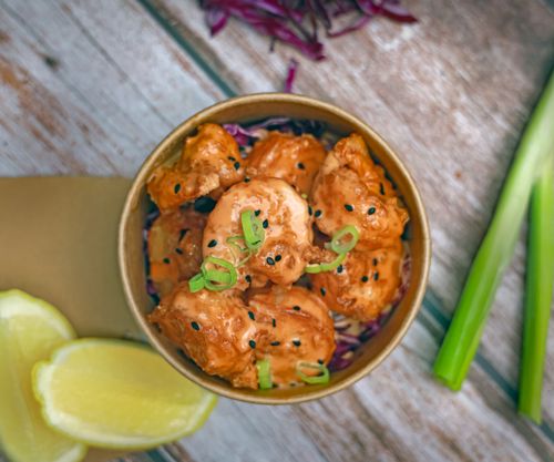 Free Delicious crispy shrimp bowl with fresh scallion and lemon garnish on rustic wooden table. Stock Photo
