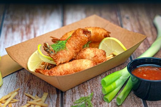 Delicious crispy shrimp served with lemon wedges and a tangy dipping sauce, perfect appetizer.