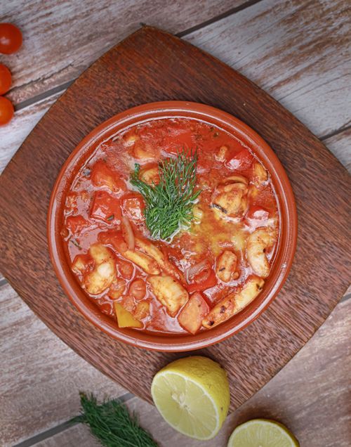 Free Savory seafood stew with tomato base served in a clay bowl, garnished with herbs, perfect for dinner. Stock Photo