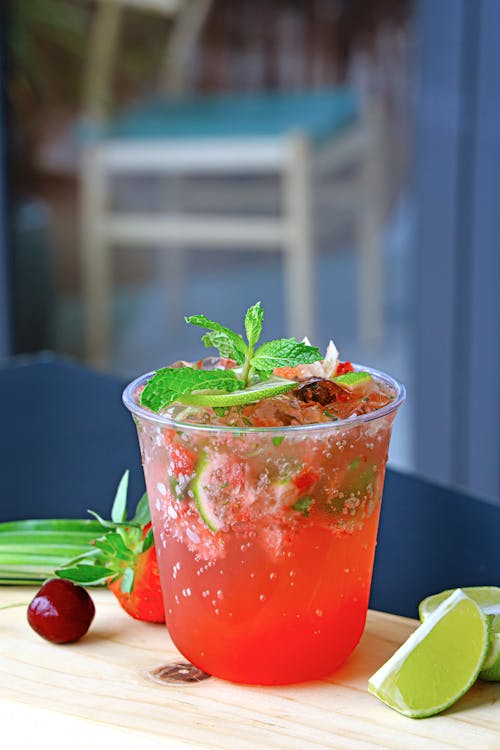 A drink with cherry, lime and mint leaves