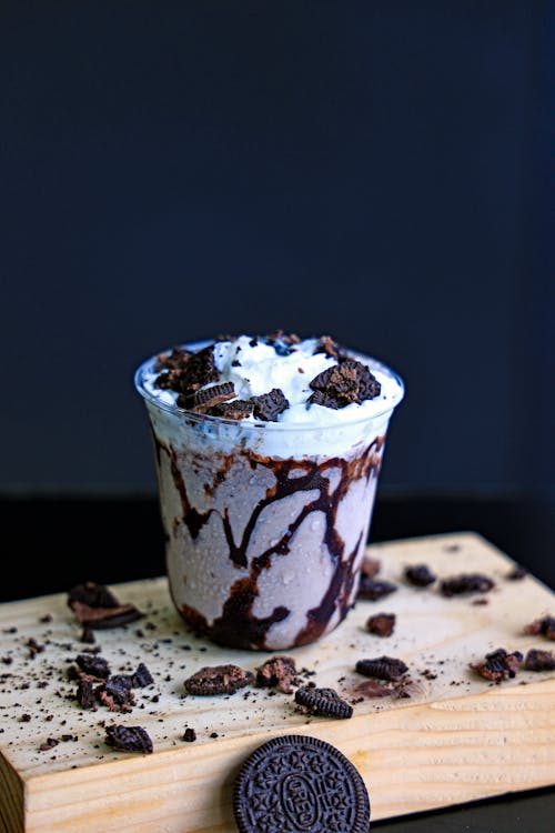 A chocolate milkshake with oreo cookies on top