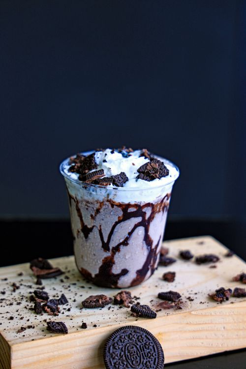 Free Indulge in a rich Oreo milkshake topped with cream and chocolate on a rustic board. Stock Photo
