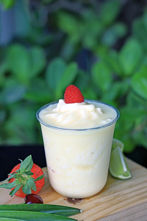 A glass of fruit juice with a strawberry and lime