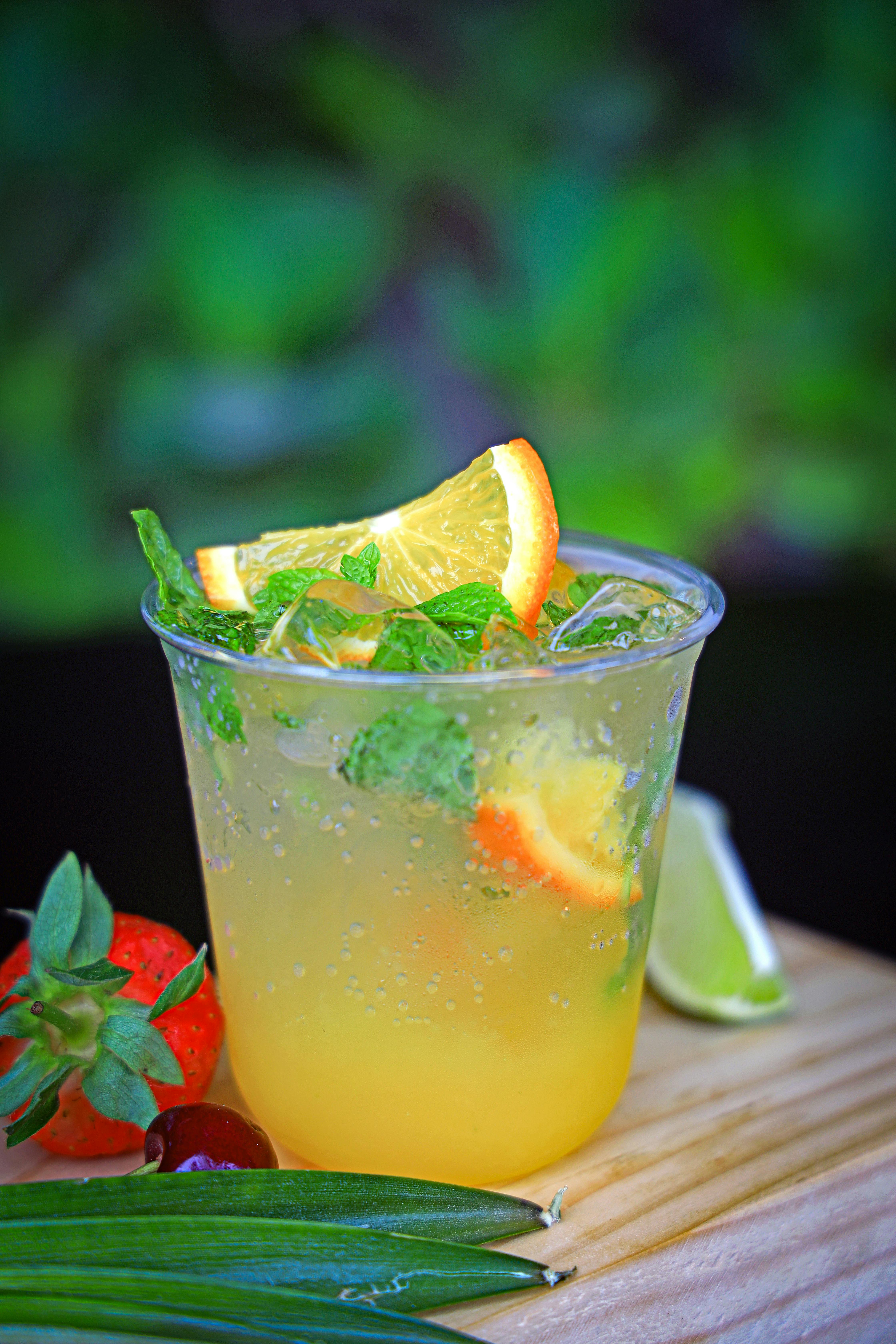 a drink with orange slices and lime on top