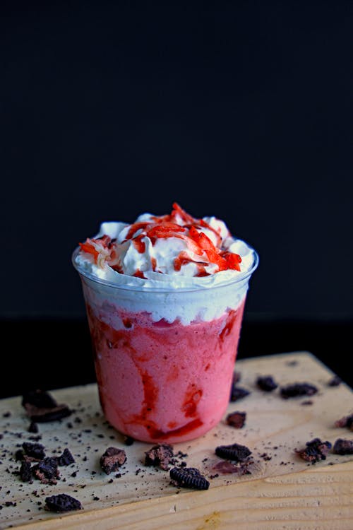 A strawberry shake with whipped cream and chocolate chips