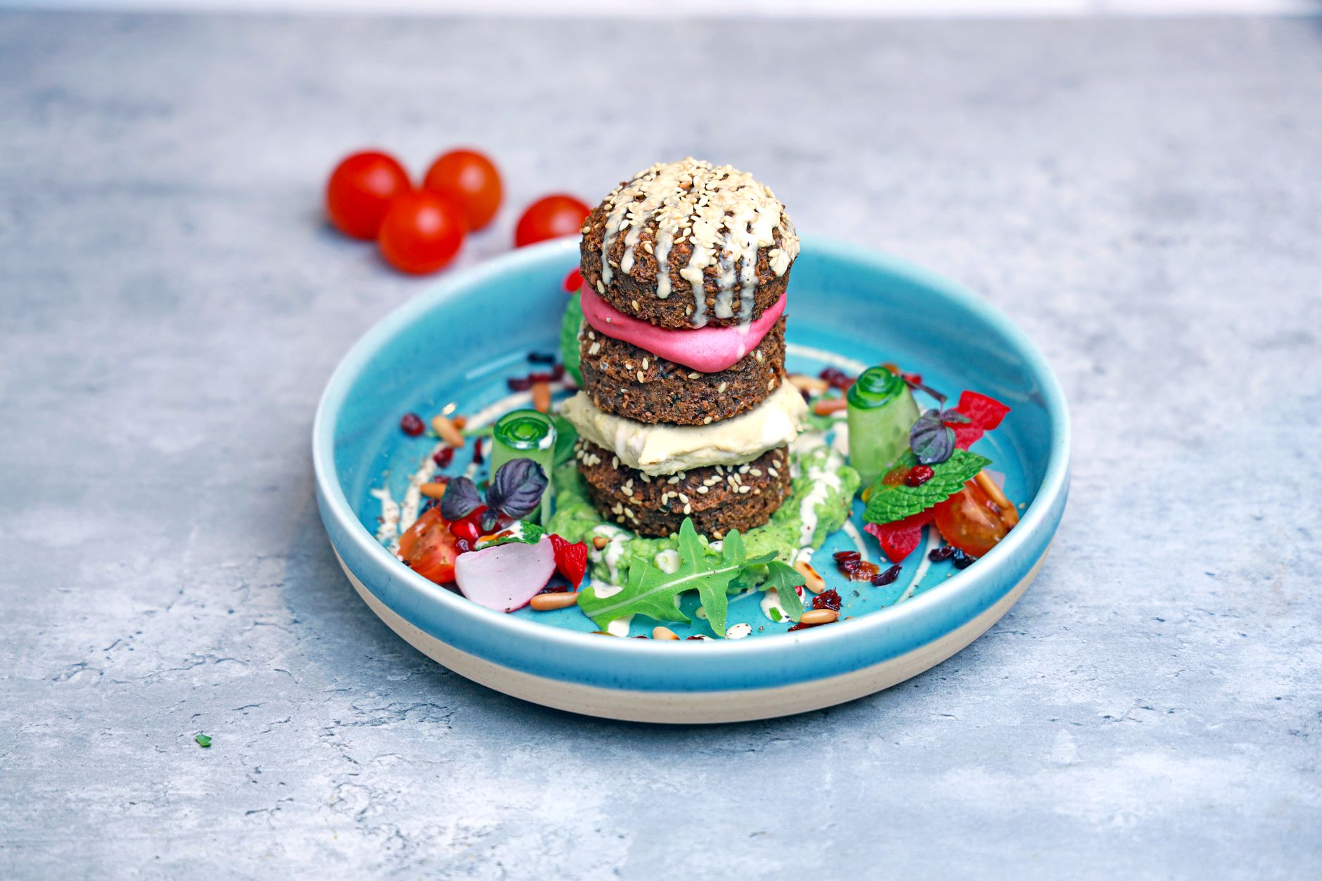 Top 5 Low Carb Salad Dressing Recipes 1 Colorful vegan breakfast with falafel stack and fresh vegetables on blue plate.