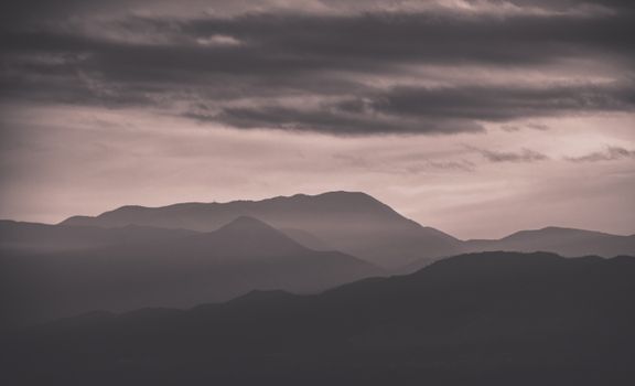 A captivating silhouette of mountains beneath a dramatic cloudy sky.