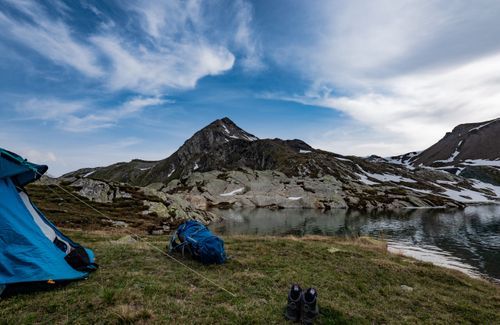 Free Scenic mountain landscape with tent setup by a tranquil lake, ideal for adventure seekers. Stock Photo