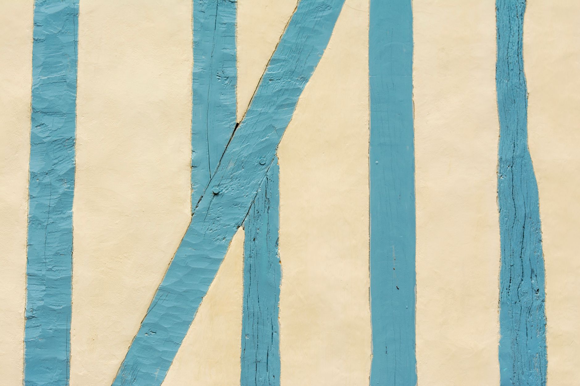 Close-up of blue painted wooden stripes on a beige wall providing a minimalist aesthetic.. close, blue, painted