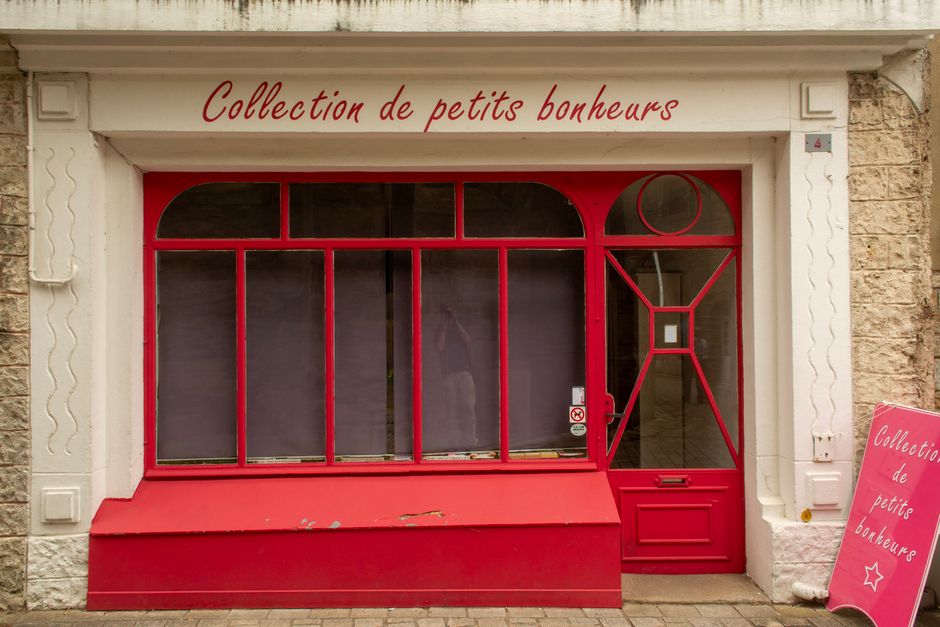Elegant red shop facade with French text 'Collection de petits bonheurs'.