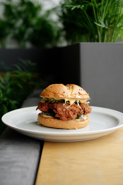 Free A savory crispy chicken sandwich with lettuce on a white plate, perfect for food lovers. Stock Photo