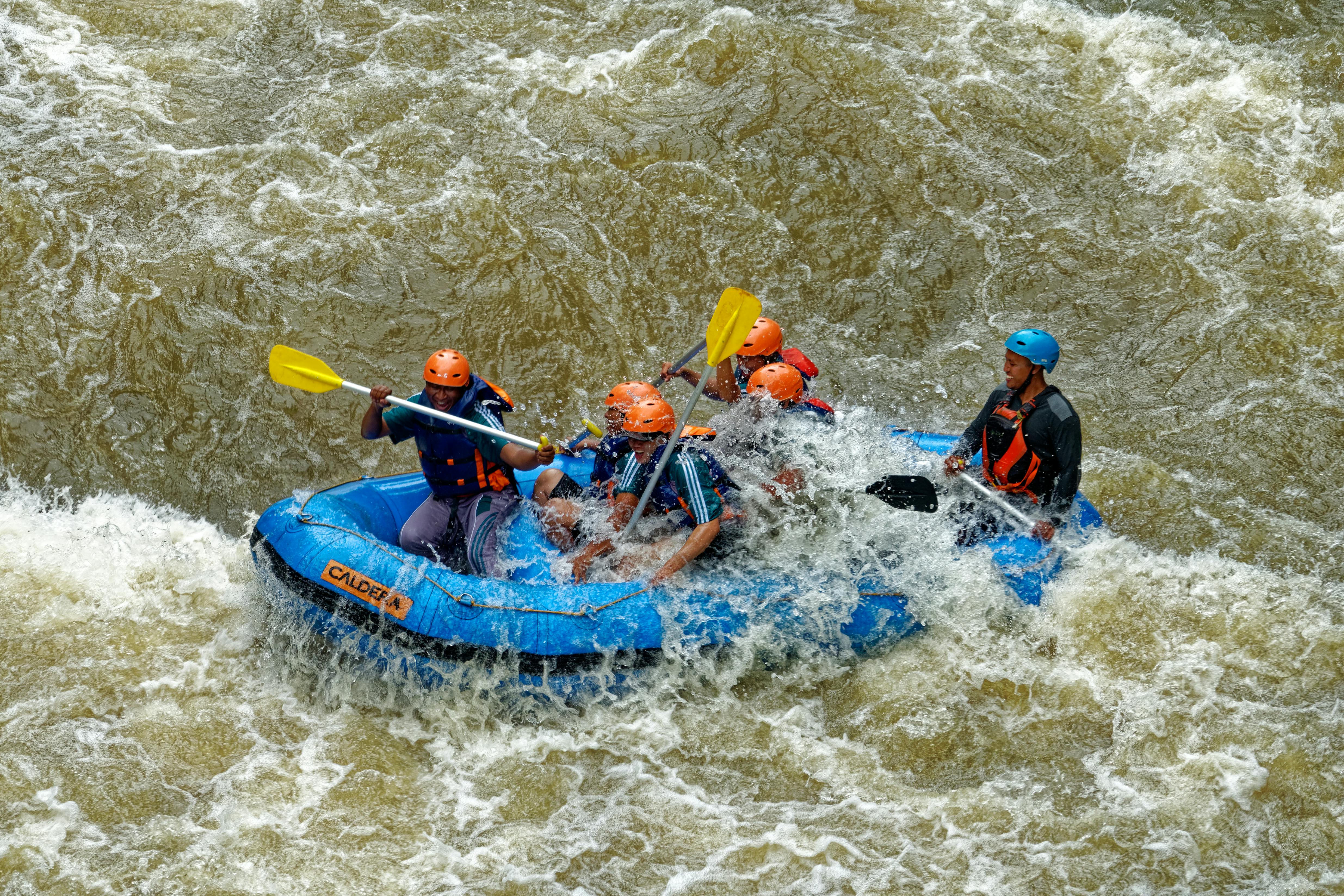 Group Of Men Paddling While Inside Inflatable Boat