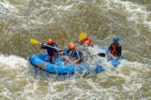 Free Group Of Men Paddling While Inside Inflatable Boat Stock Photo