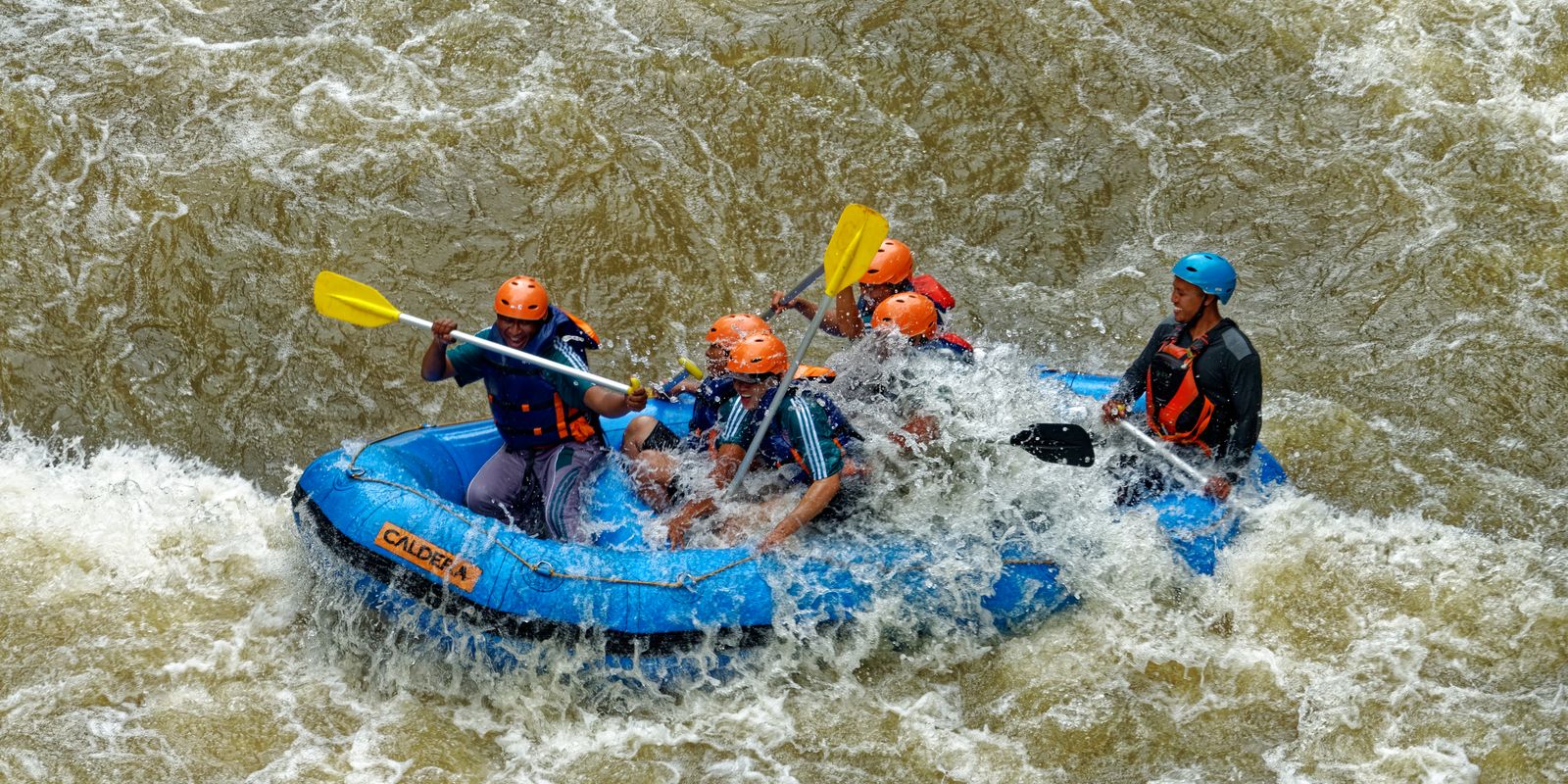 Group whitewater rafting through rapids