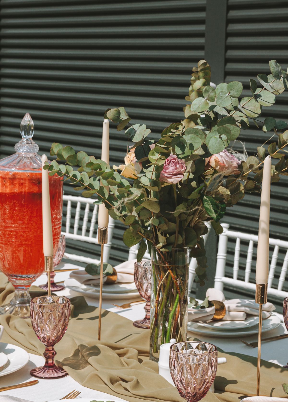 A sunlit table setting featuring candles, floral arrangements, and glassware, perfect for celebrations. Stock Photo.